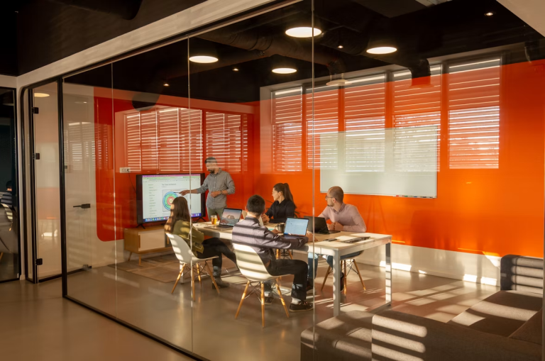 Team members collaborating in a bright, clean conference room during a business meeting in a modern office.
