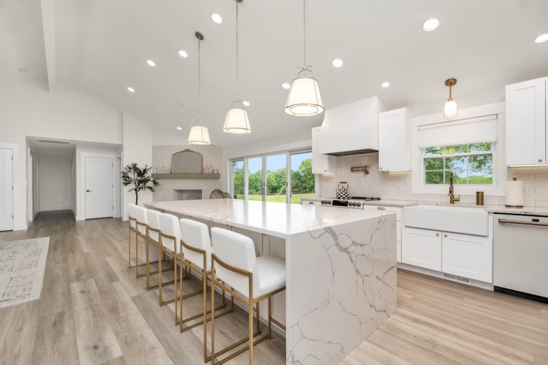 Modern open-concept kitchen featuring a large quartz island, white cabinetry, and updated finishes that add long-term value to a home.