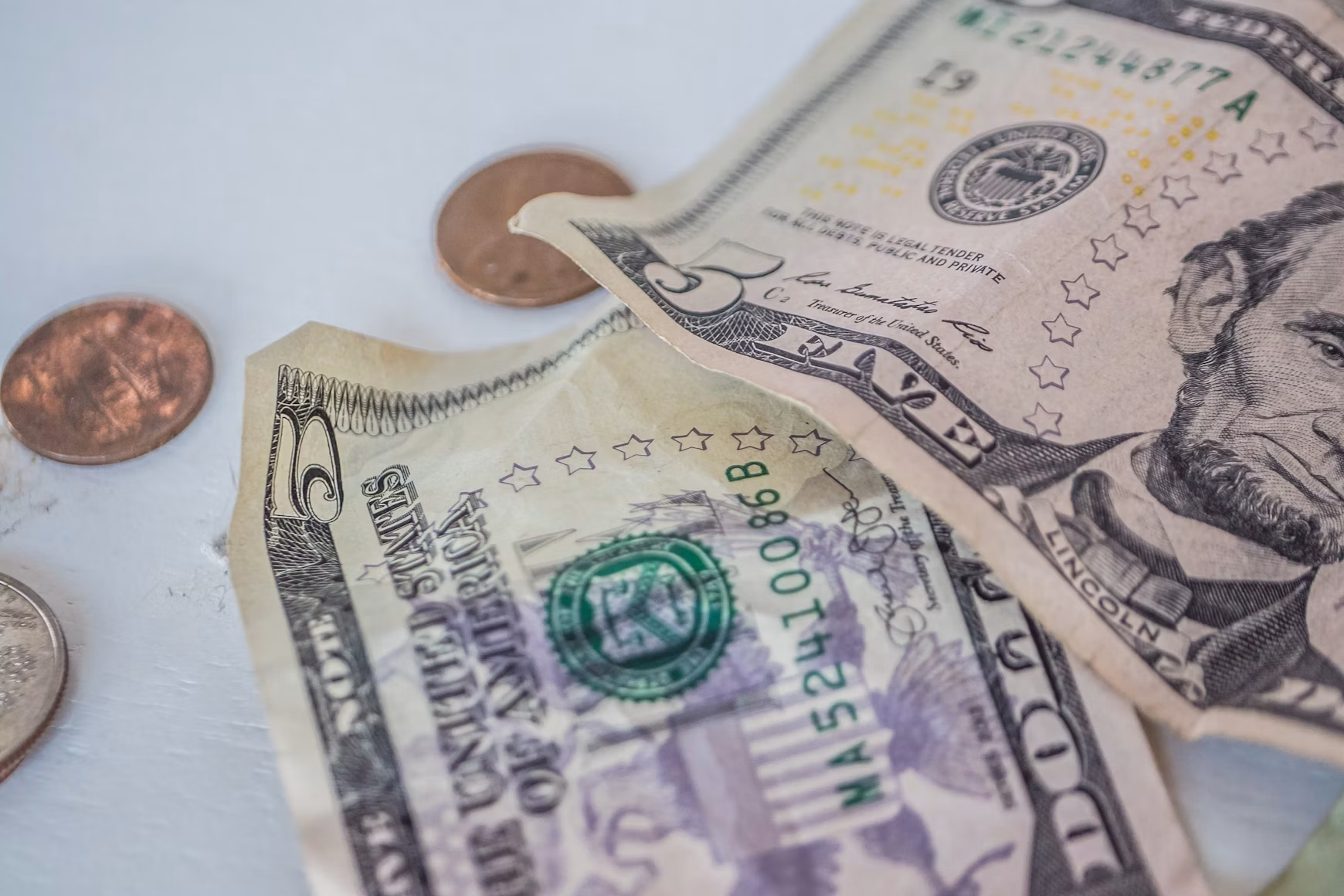 U.S. dollar bills and coins representing budgeting, saving, investing, and long-term wealth accumulation.