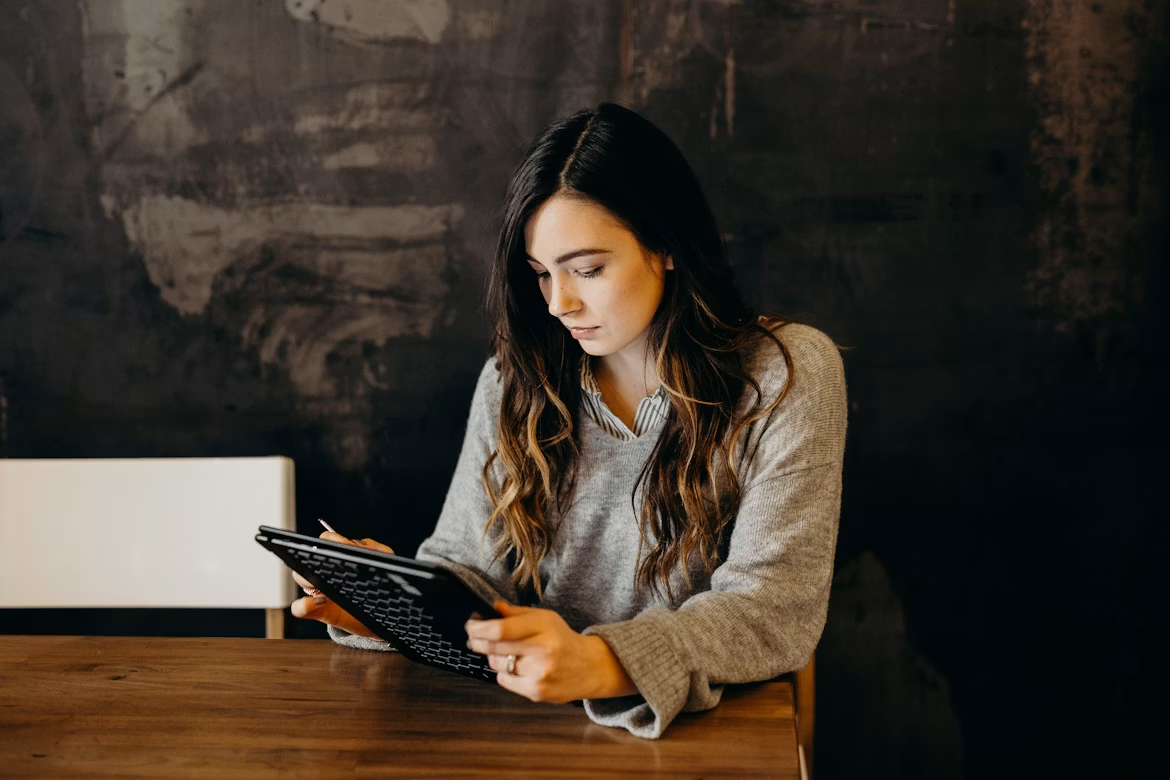 Entrepreneur reviewing business information on a tablet while planning workflow improvements and operational goals.