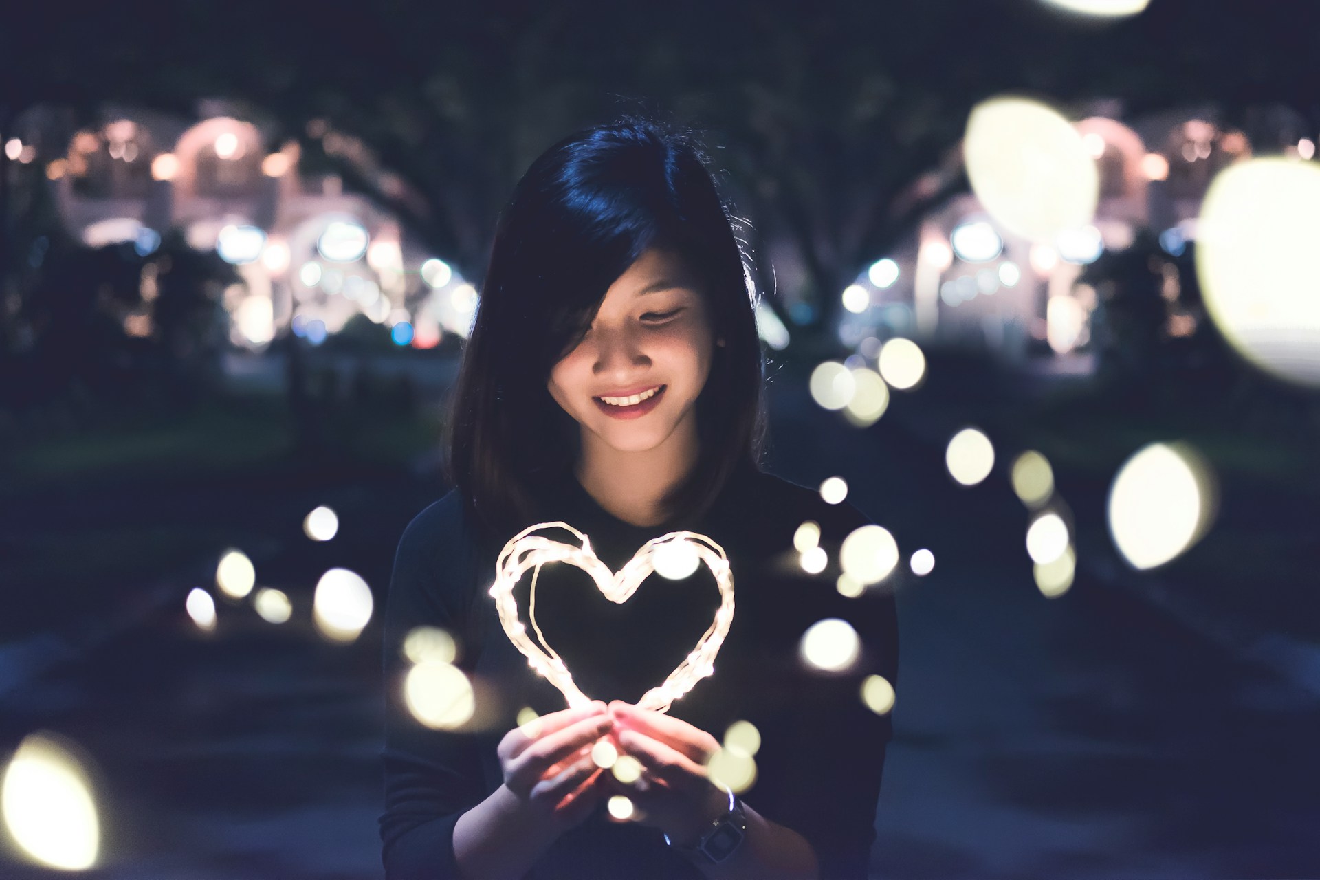 Woman holding a glowing heart representing self-trust, confidence, and listening to your own voice