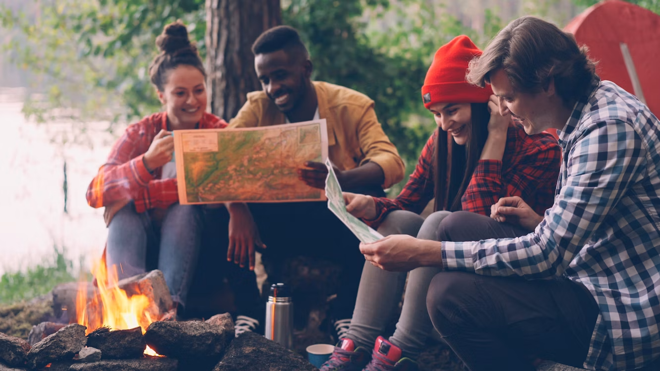 Friends looking at maps together while planning a group celebration getaway