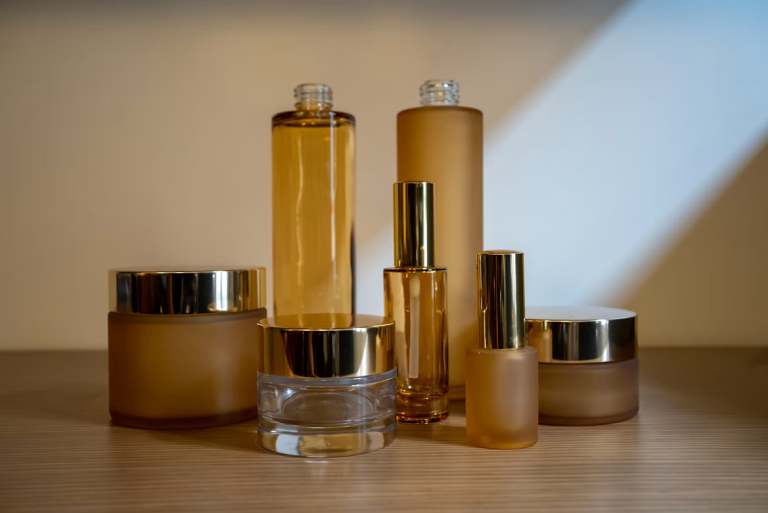Glass and frosted cosmetic containers displayed on a tabletop, showcasing packaging options for skincare and beauty products.