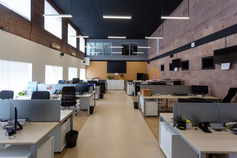 Modern office workspace with ergonomic desks, open walkways, and collaborative work areas designed to improve productivity.