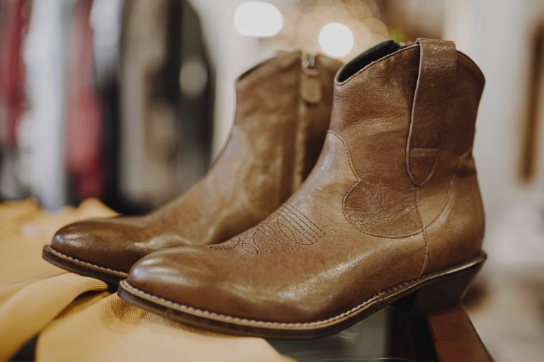 Pair of high-quality brown leather ankle boots displayed on a wooden surface, highlighting timeless craftsmanship and durable design.