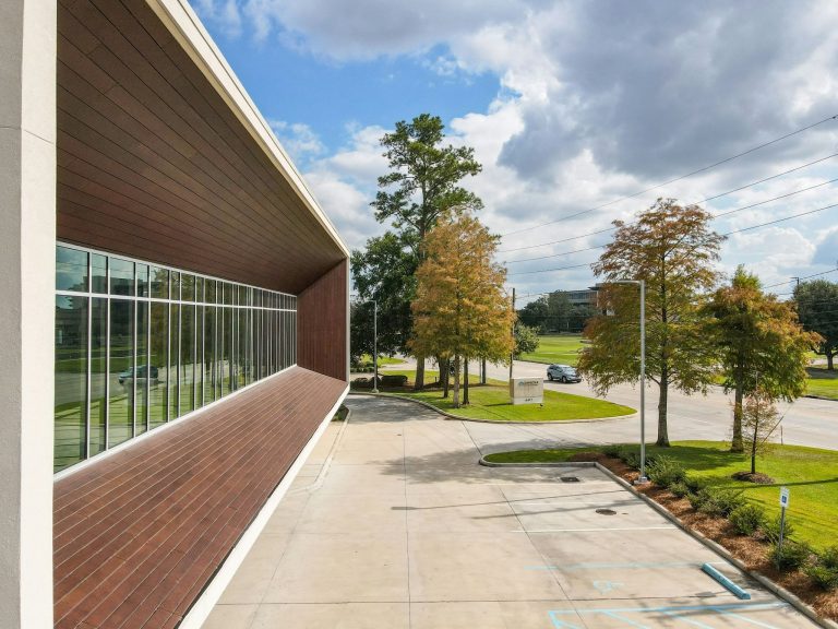 Modern commercial building with parking area and landscaped surroundings