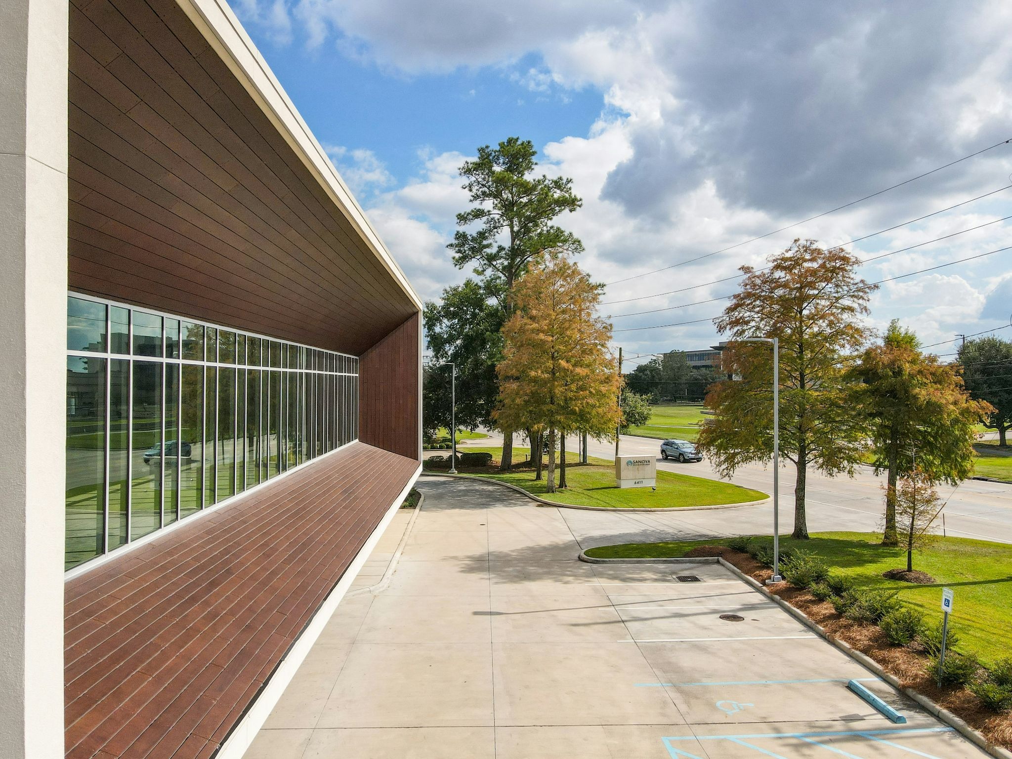 Modern commercial building with parking area and landscaped surroundings