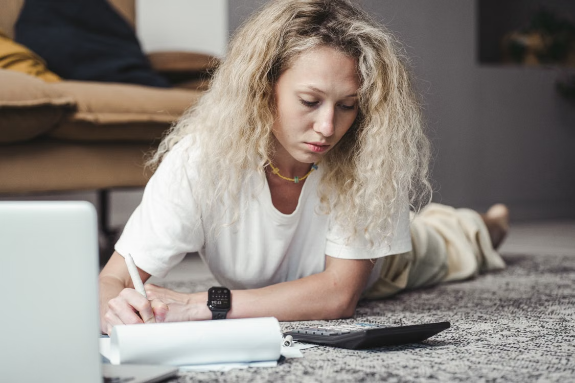 Woman calculating expenses and taking notes while planning her first investment property