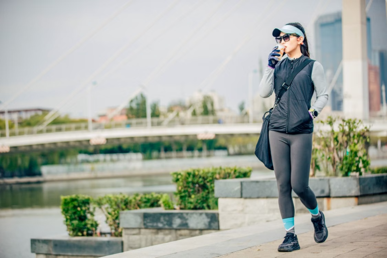 Woman in activewear taking a water break during an outdoor walk