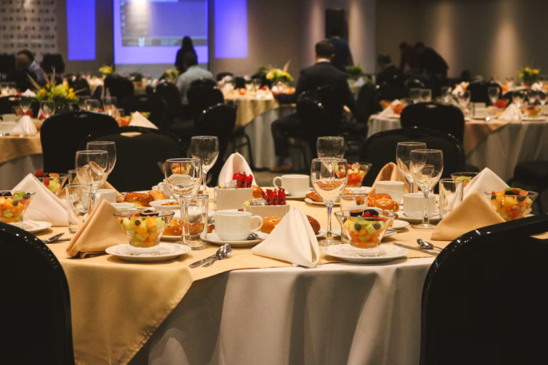 Formal business event with decorated banquet tables and a presentation screen