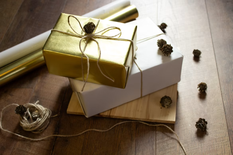 Gold and white gift boxes wrapped with twine and decorated with small pinecones