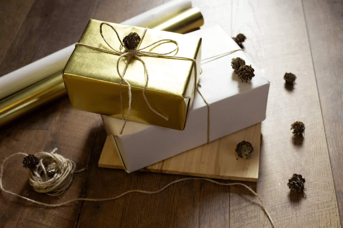 Gold and white gift boxes wrapped with twine and decorated with small pinecones